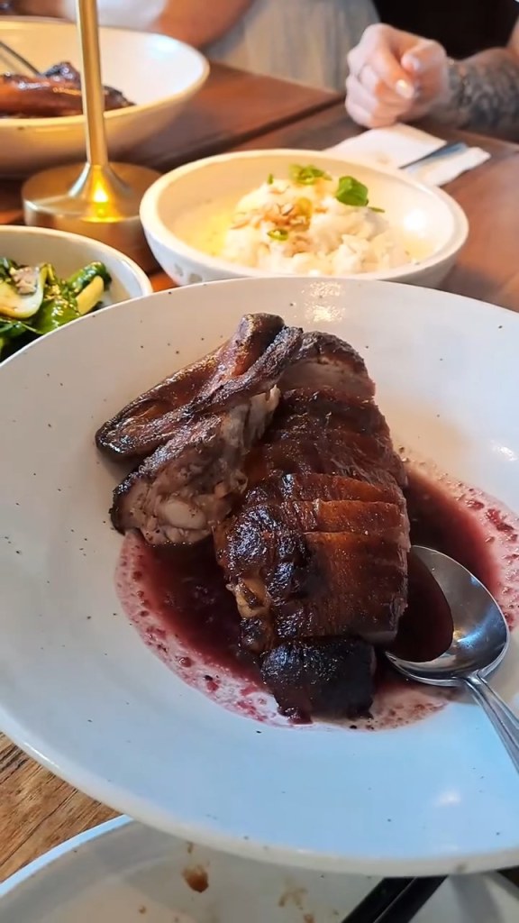 A glossy glazed main with sauce and sides at Baahlah, Geelong