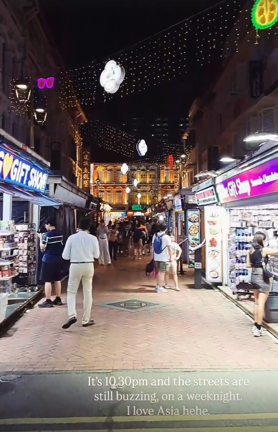 A busy Chinatown street at night under strings of lights