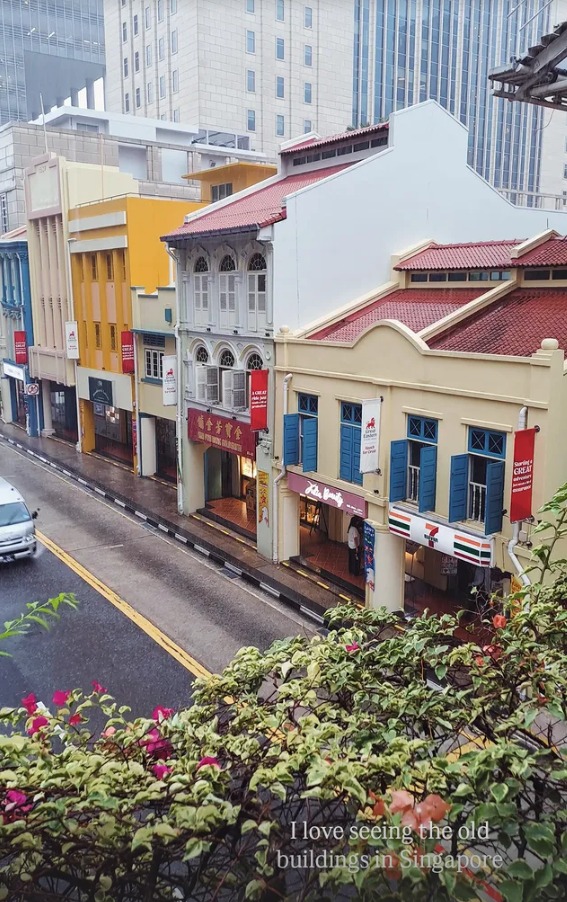 Colourful old shophouses with blue shutters on a rainy street