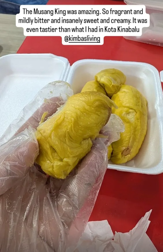 A gloved hand holding a piece of Musang King durian