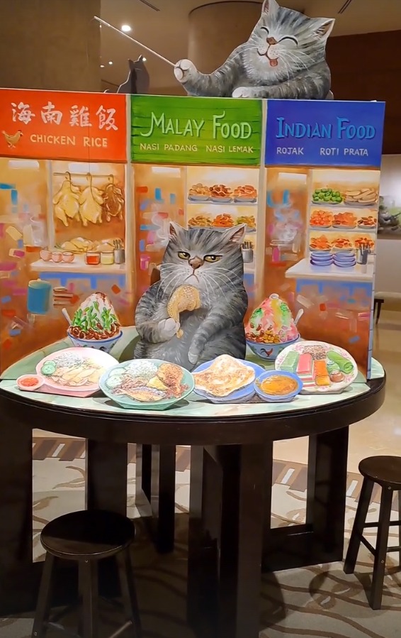 A cat art installation of a cat at a hawker centre table
