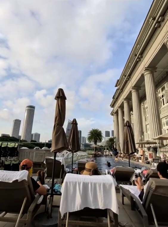 View from a sun lounger across the pool to the city skyline