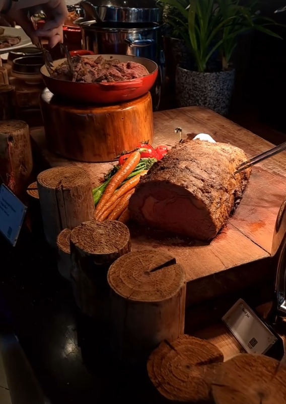 Roast beef on a carving board with vegetables