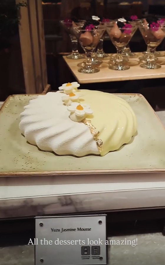 A yuzu jasmine mousse decorated with flowers and gold leaf