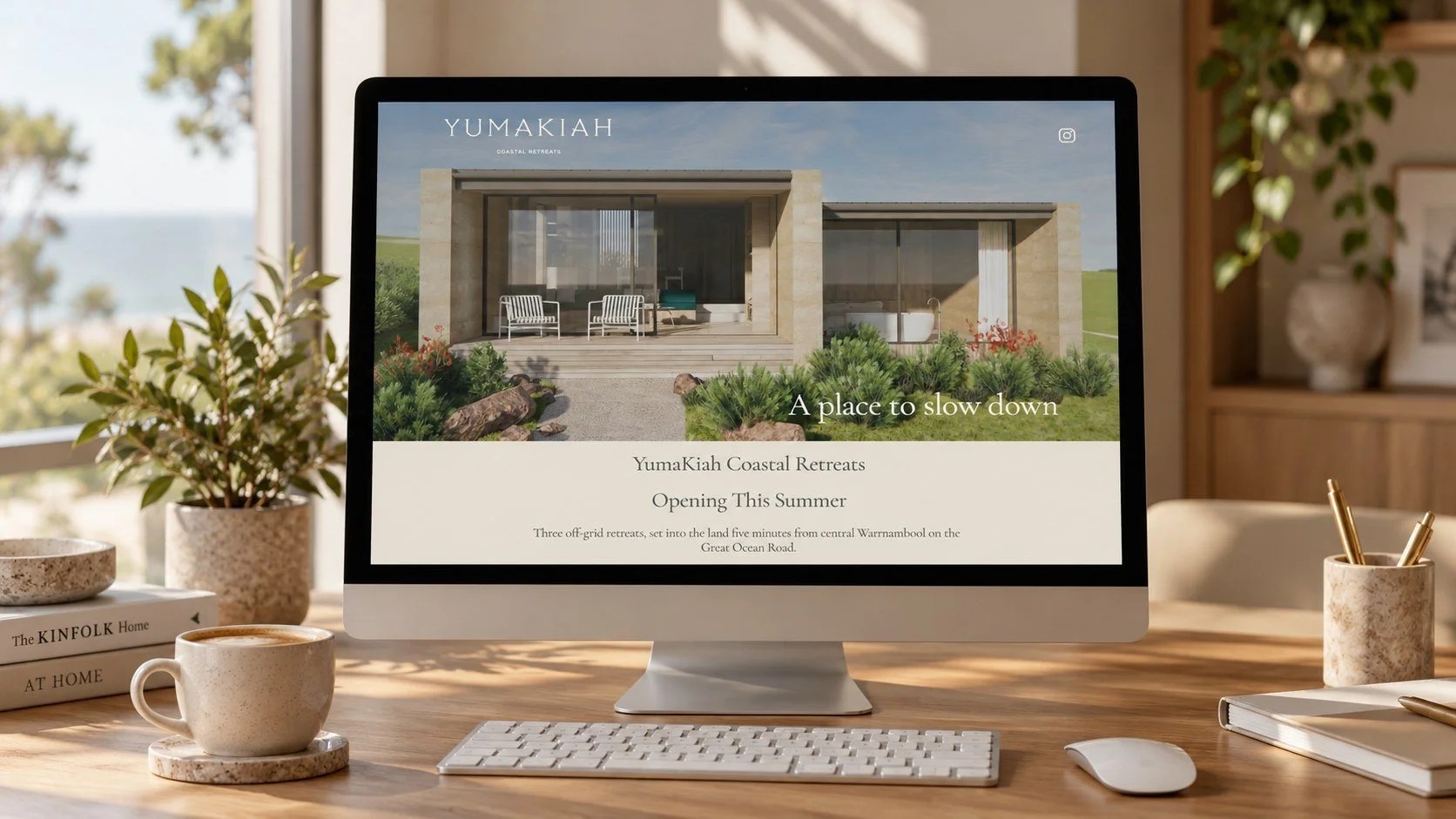 Desktop computer on a timber desk displaying the YumaKiah Coastal Retreats website