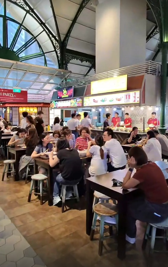 Diners at tables in the busy hawker hall