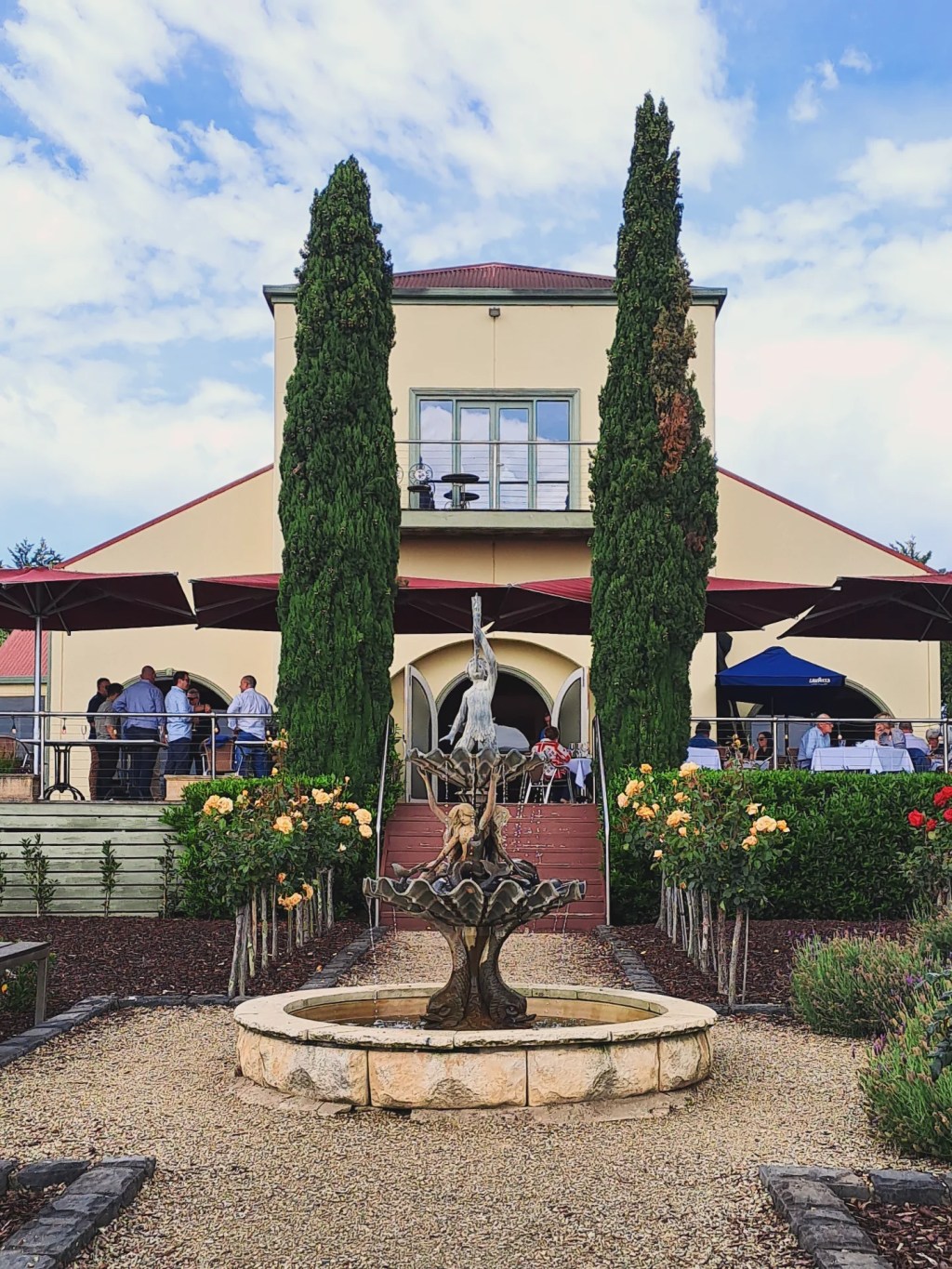 The Tokar Estate building with cypress trees and a fountain in the courtyard