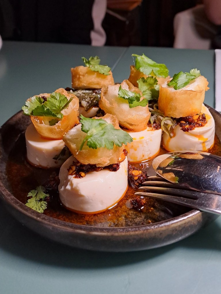 Tofu pieces topped with herbs and chilli oil