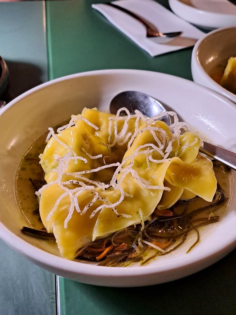 Wontons in sauce topped with shredded garnish